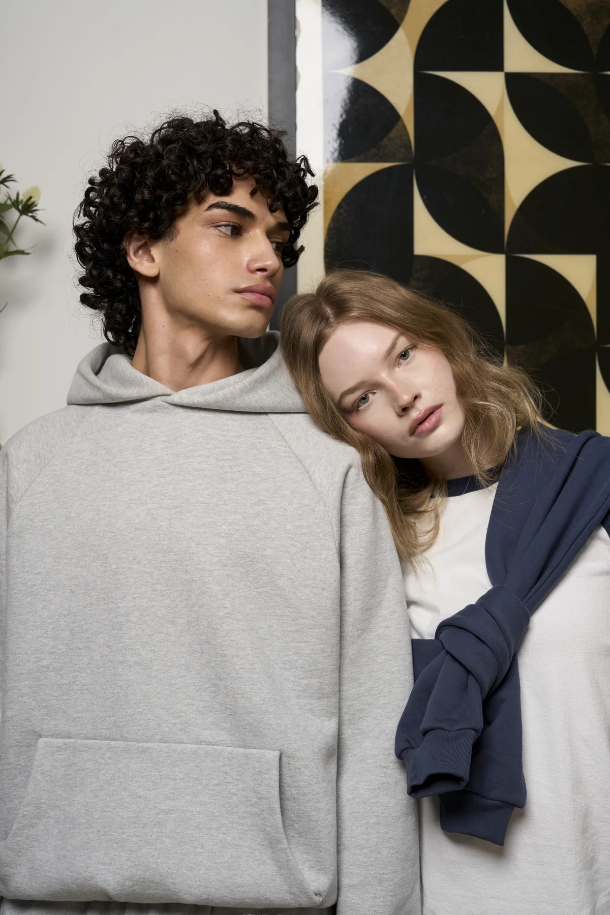 Two models leaning together in grey and navy apparel